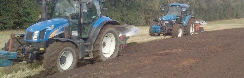 To traktorer er i gang med at pløje en mark